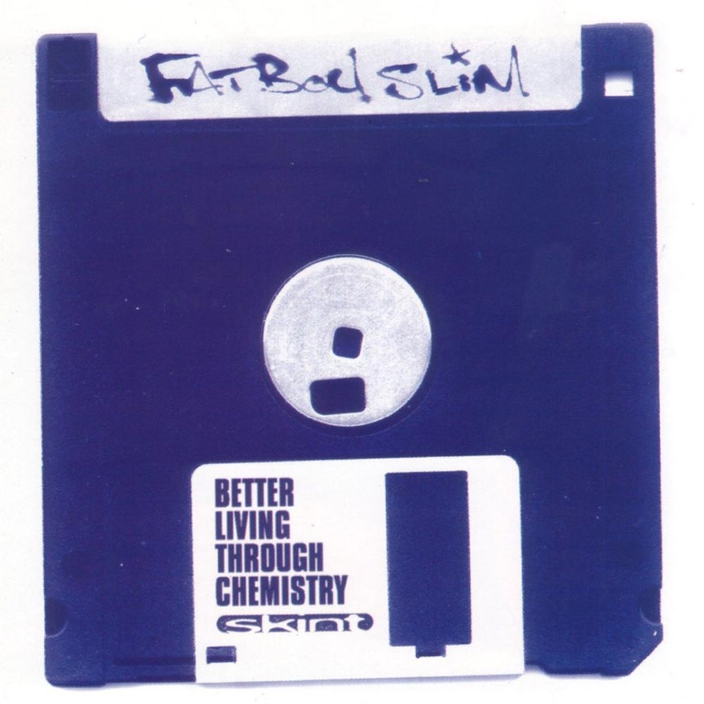 Eine klassische, dunkelblaue 3,5-Zoll-Diskette. Im oberen Bereich ist mit schwarzem Filzstift der Schriftzug „Fatboy Slim“ zu sehen. Im unteren Drittel befindet sich ein weißes Label mit der Aufschrift „BETTER LIVING THROUGH CHEMISTRY“. Darunter steht das Logo „SKINT“.