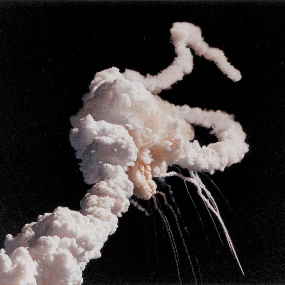 Das Bild zeigt vor schwarzem Hintergrund eine große, chaotische Wolke aus weißem Rauch, die durch eine Explosion entstanden ist. Einzelne Rauchstränge breiten sich in verschiedene Richtungen aus. Keine weiteren Objekte sind zu sehen.