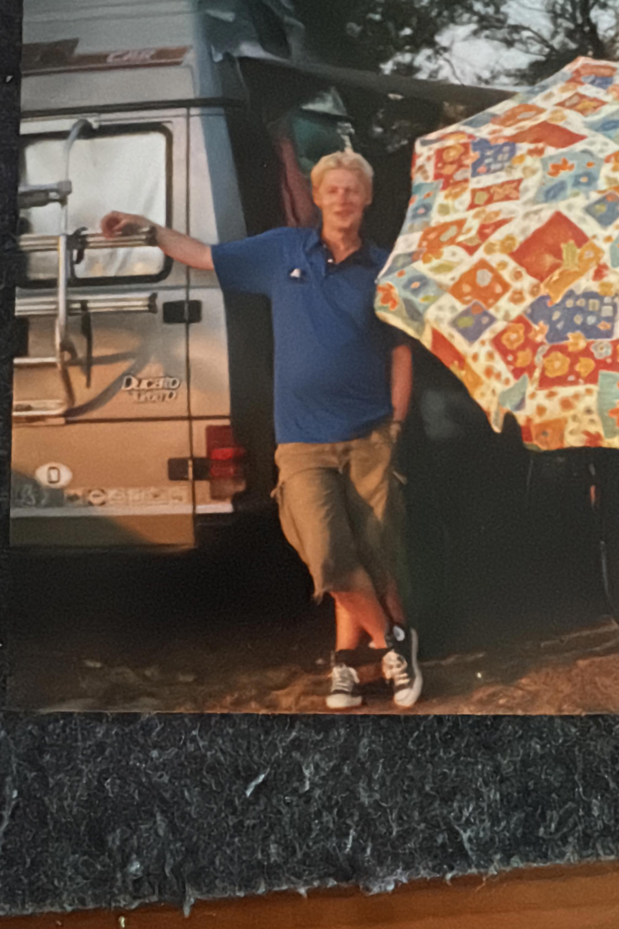 Yours truly in Saint-Jean-de-Luz in Frankreich zwischen einem Fiat-Wohnmobil und einem Sonnenschirm mit Blümchenmuster.
